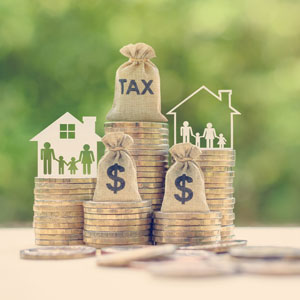 Coins and money with family and house in the background, symbolizing taxes - Donald Janklow Attorney at Law